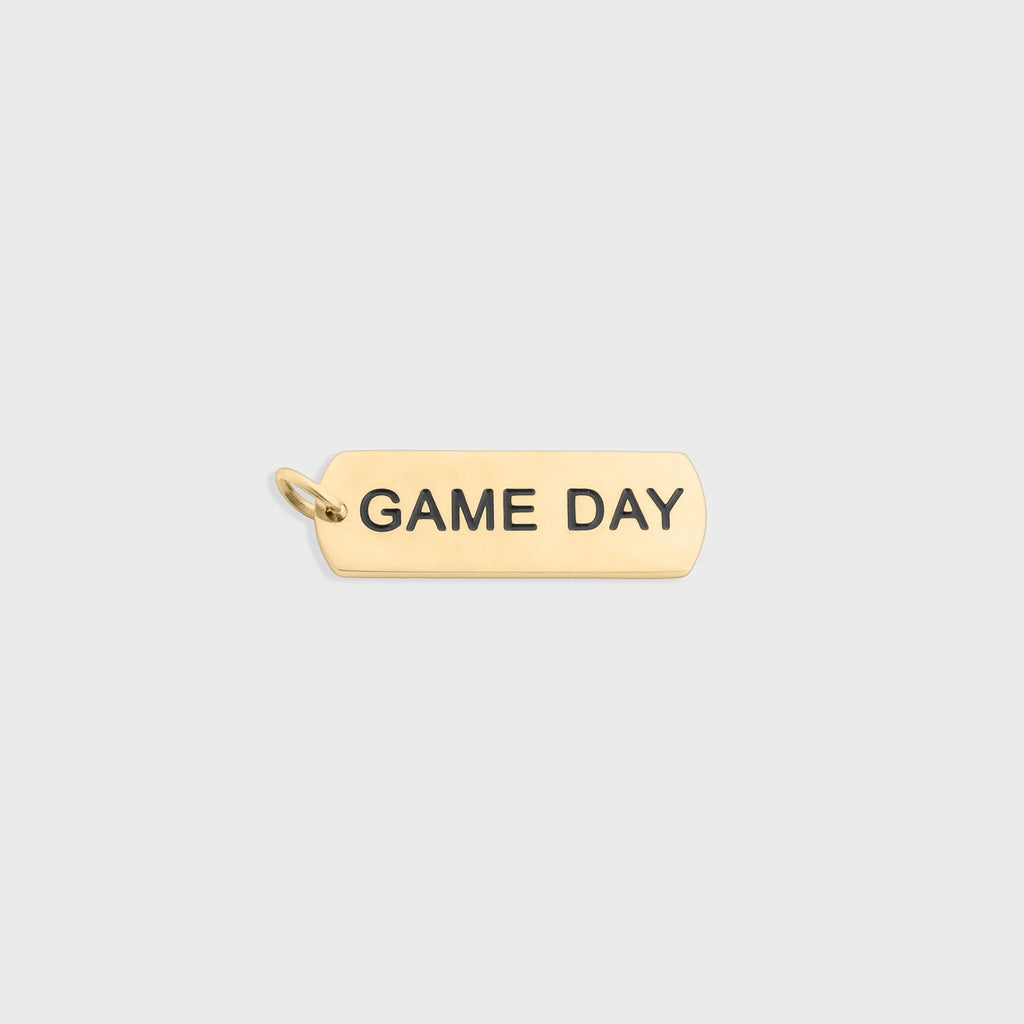 Gold pendant with 'GAME DAY' engraving on a white background