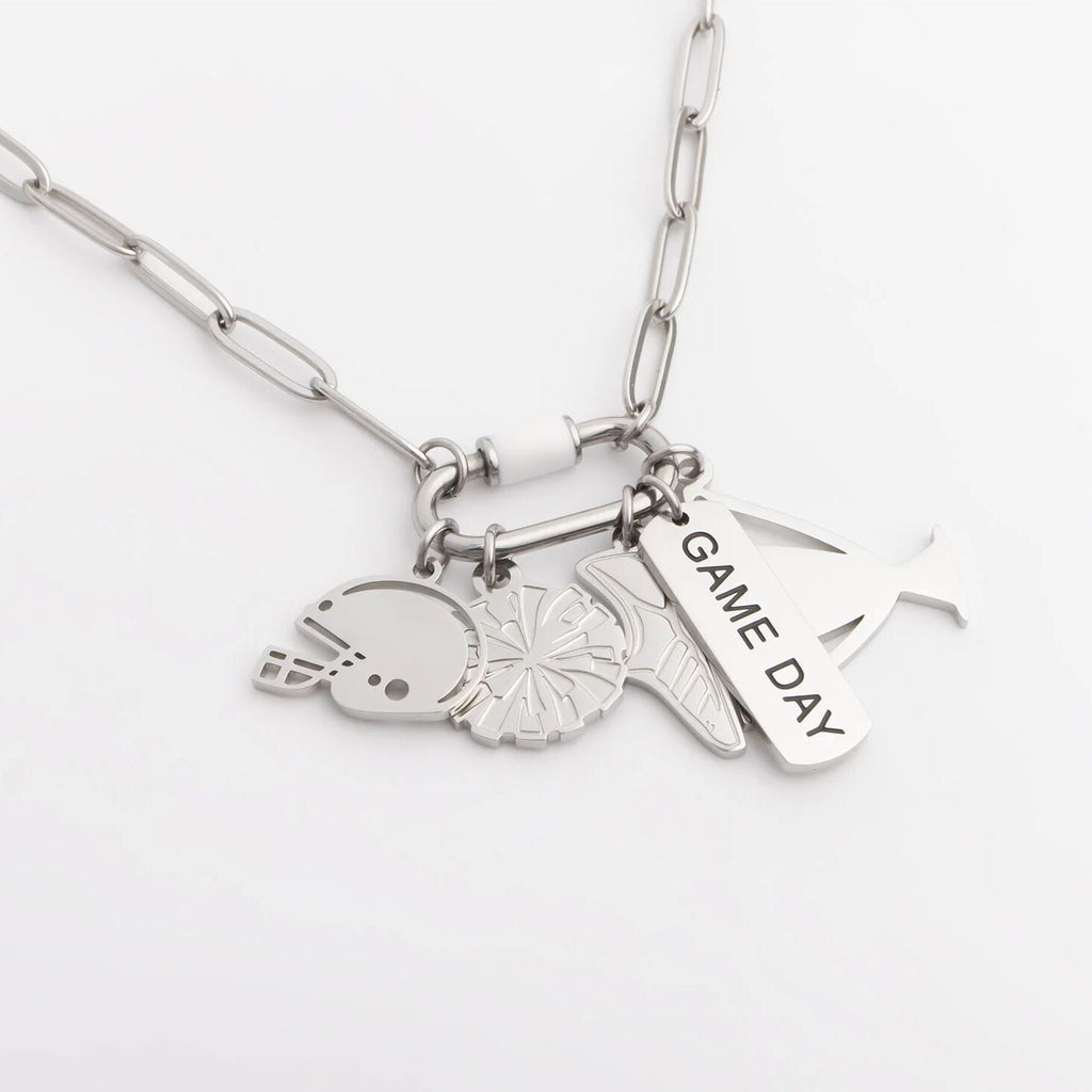 Silver necklace with various charms on a white background