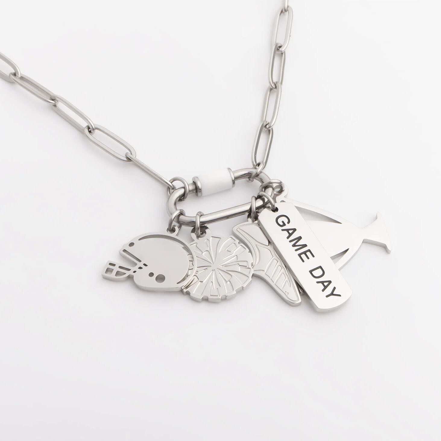 Silver necklace with various charms on a white background