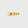 Gold pendant with 'LET'S GO' text on a light gray background
