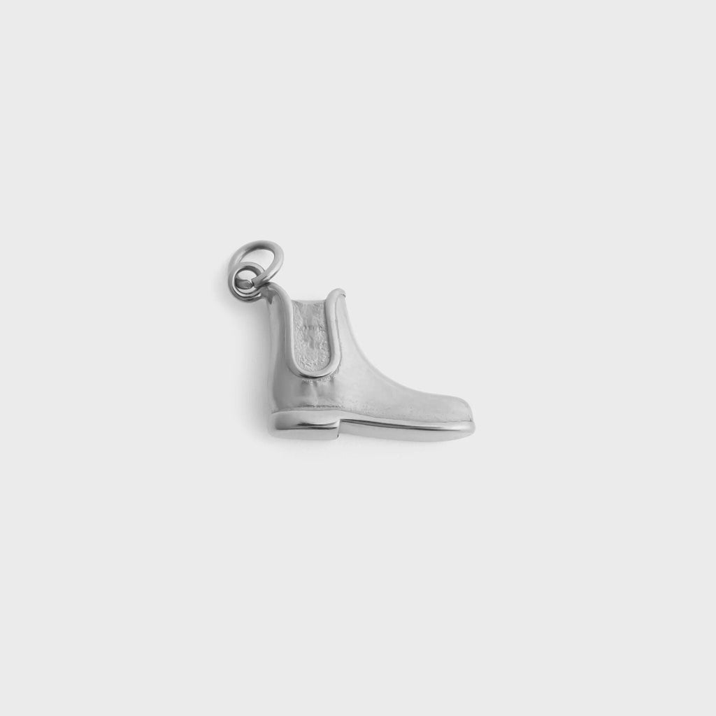 Silver equestrian boot pendant on a light gray background