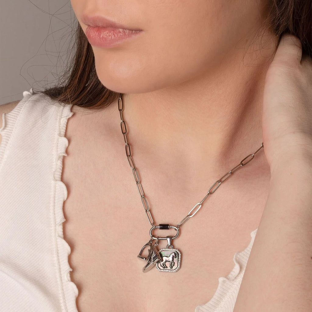 Close-up of a woman wearing a silver necklace with equestrian charms.