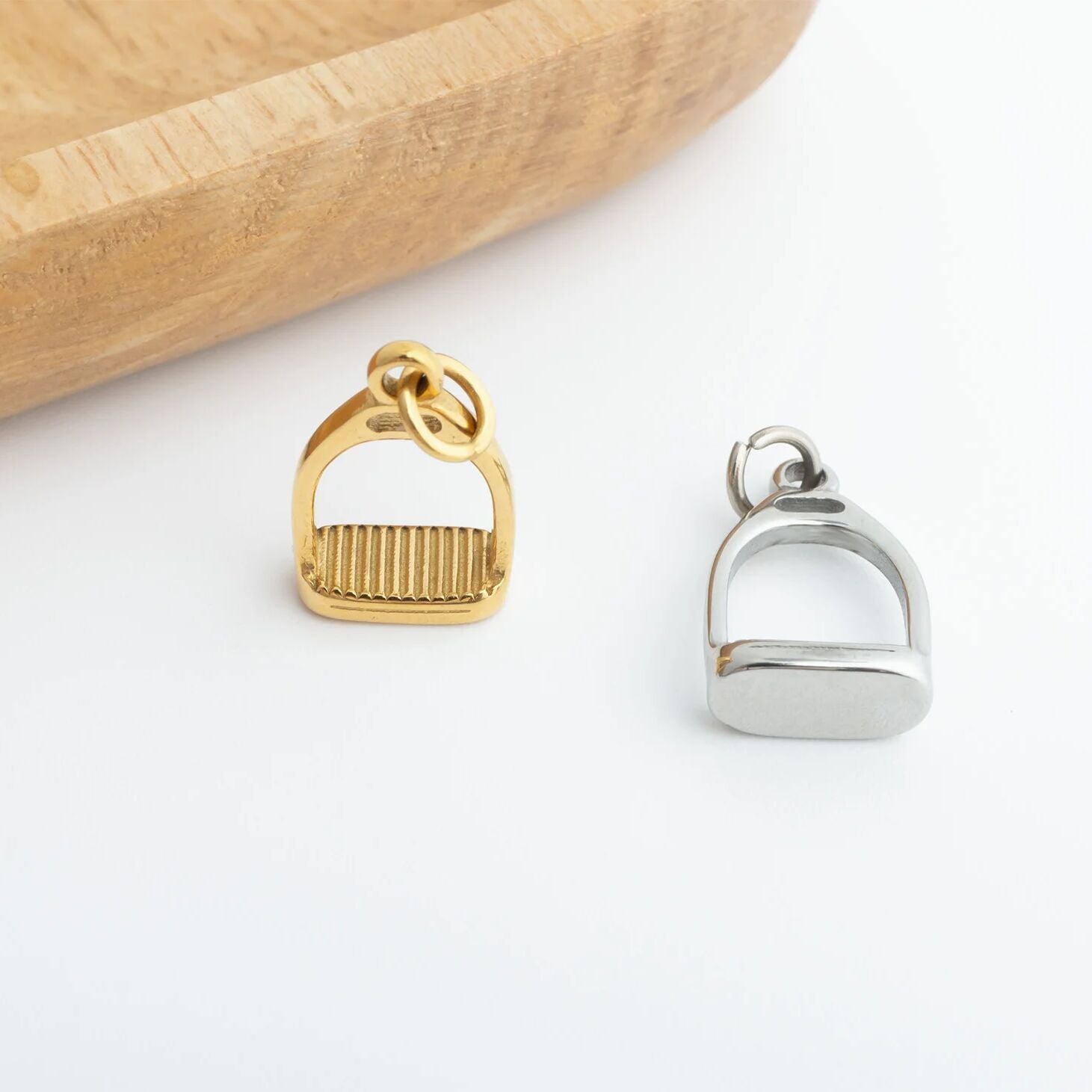 Gold and silver stirrup pendants on a white background
