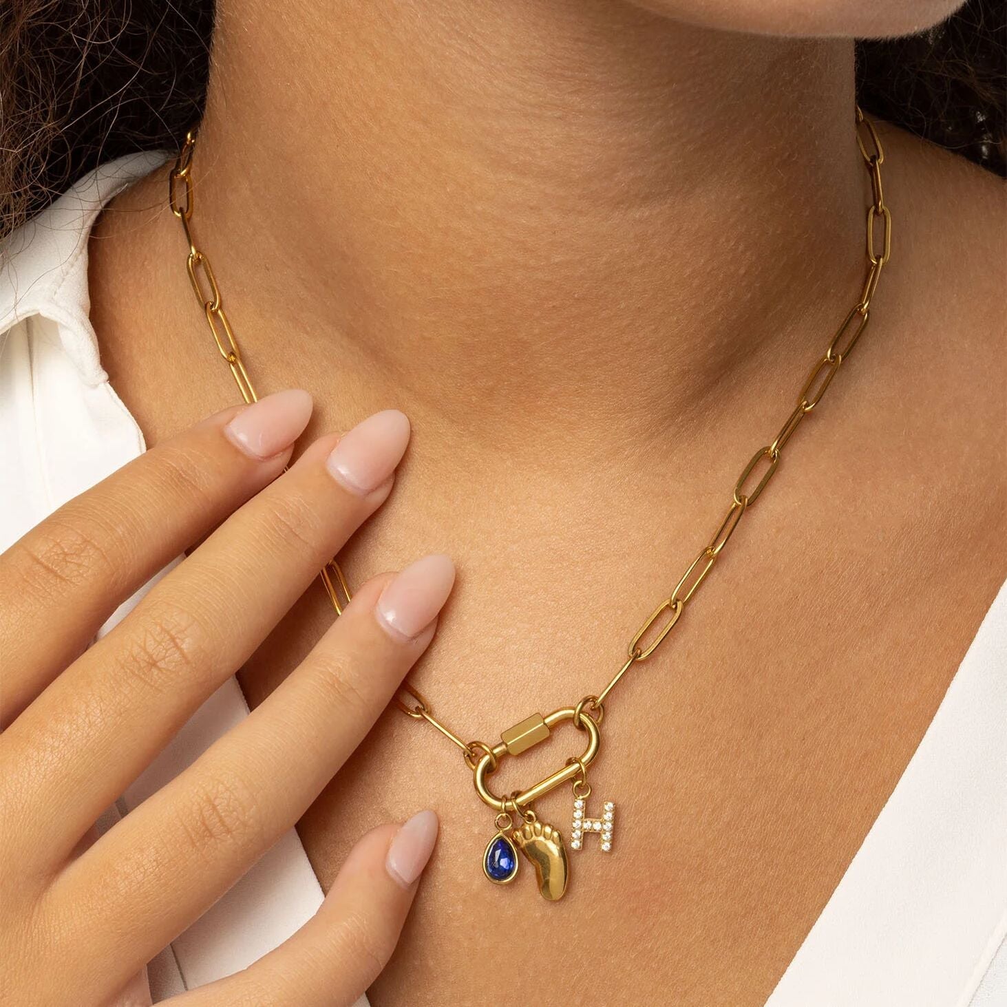 Gold necklace with charms on a person's neck