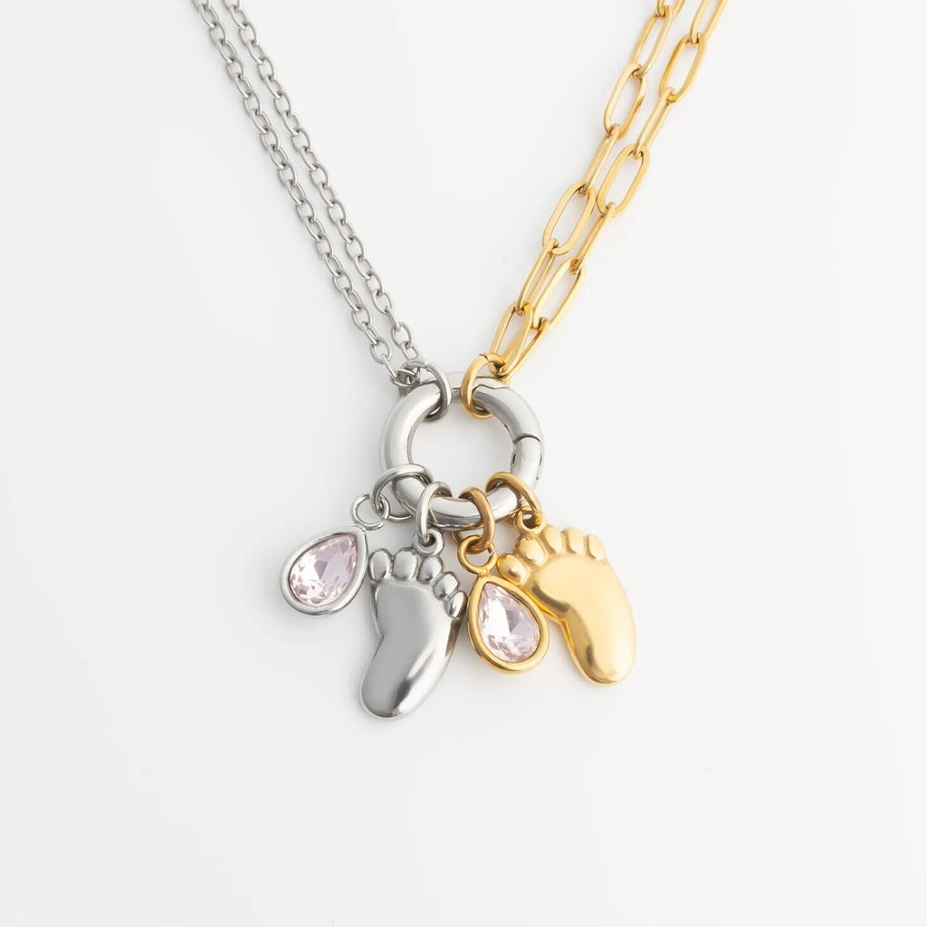 Necklace with foot charms and birthstone charms on a white background