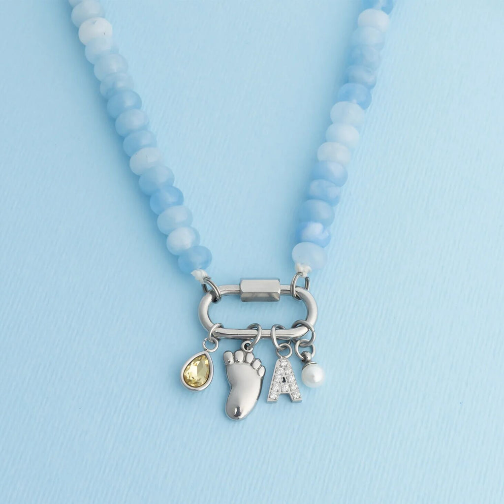 Necklace with baby-themed charms on a light blue background