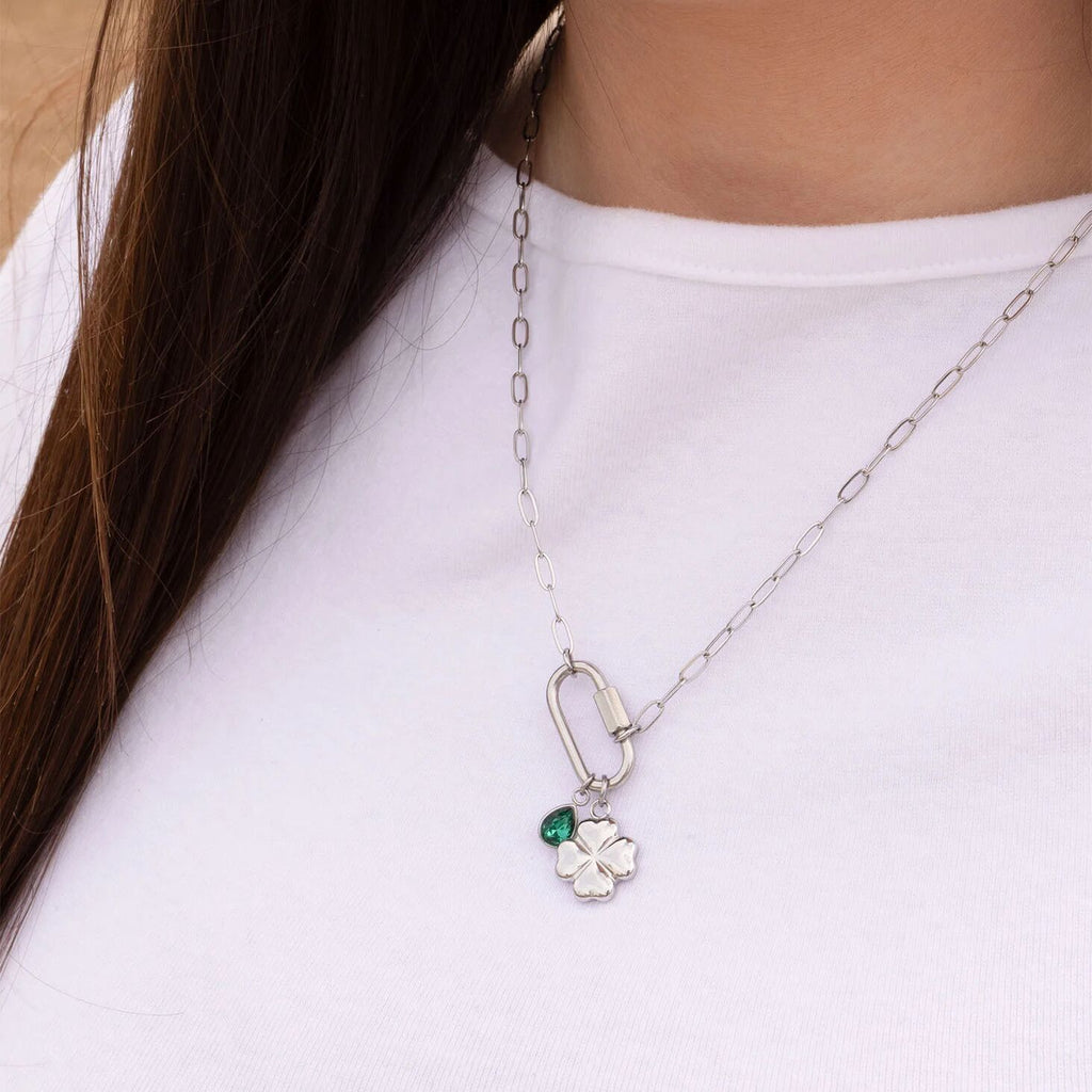 Necklace with a clover pendant and green gemstone on a white background