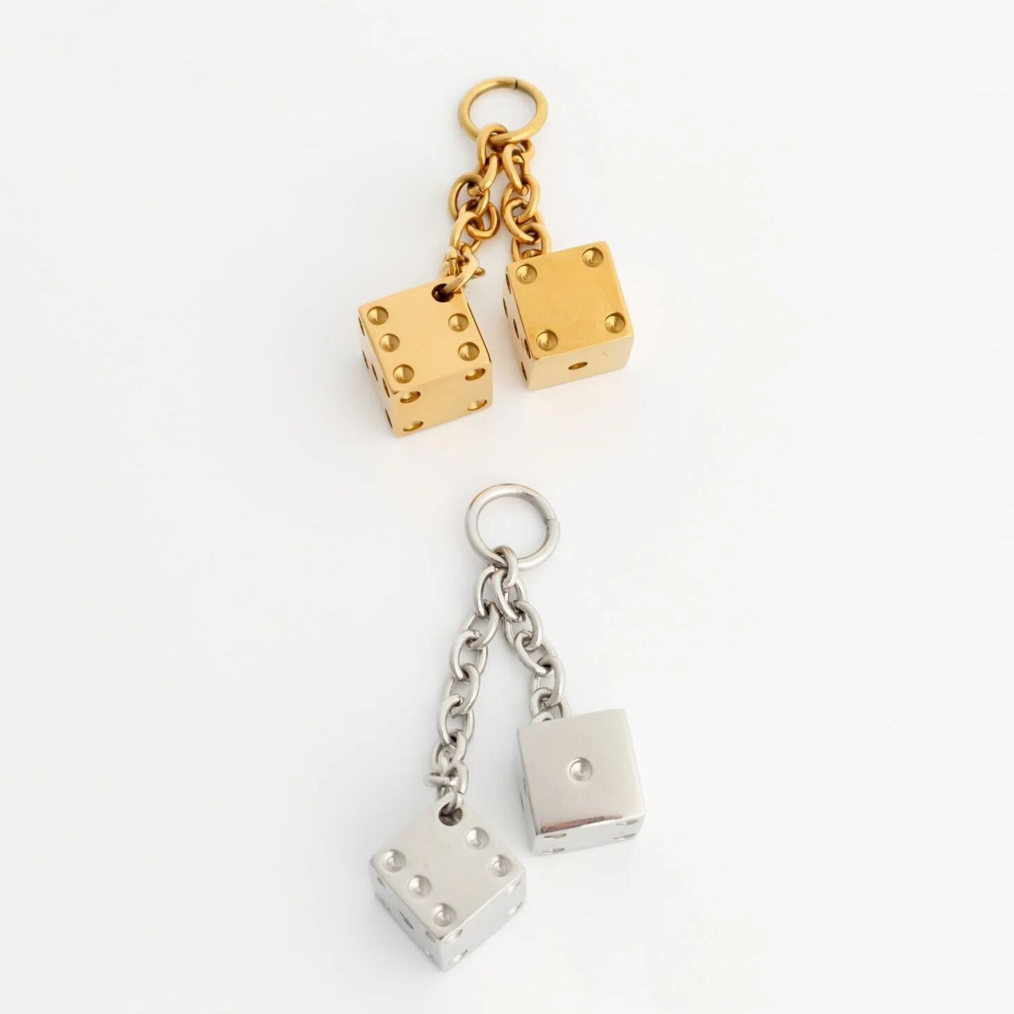 Gold and silver dice pendant on a white background