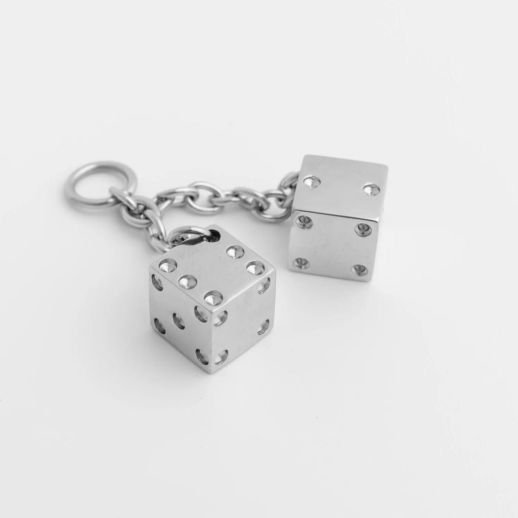 Silver dice charm with chain on a white background