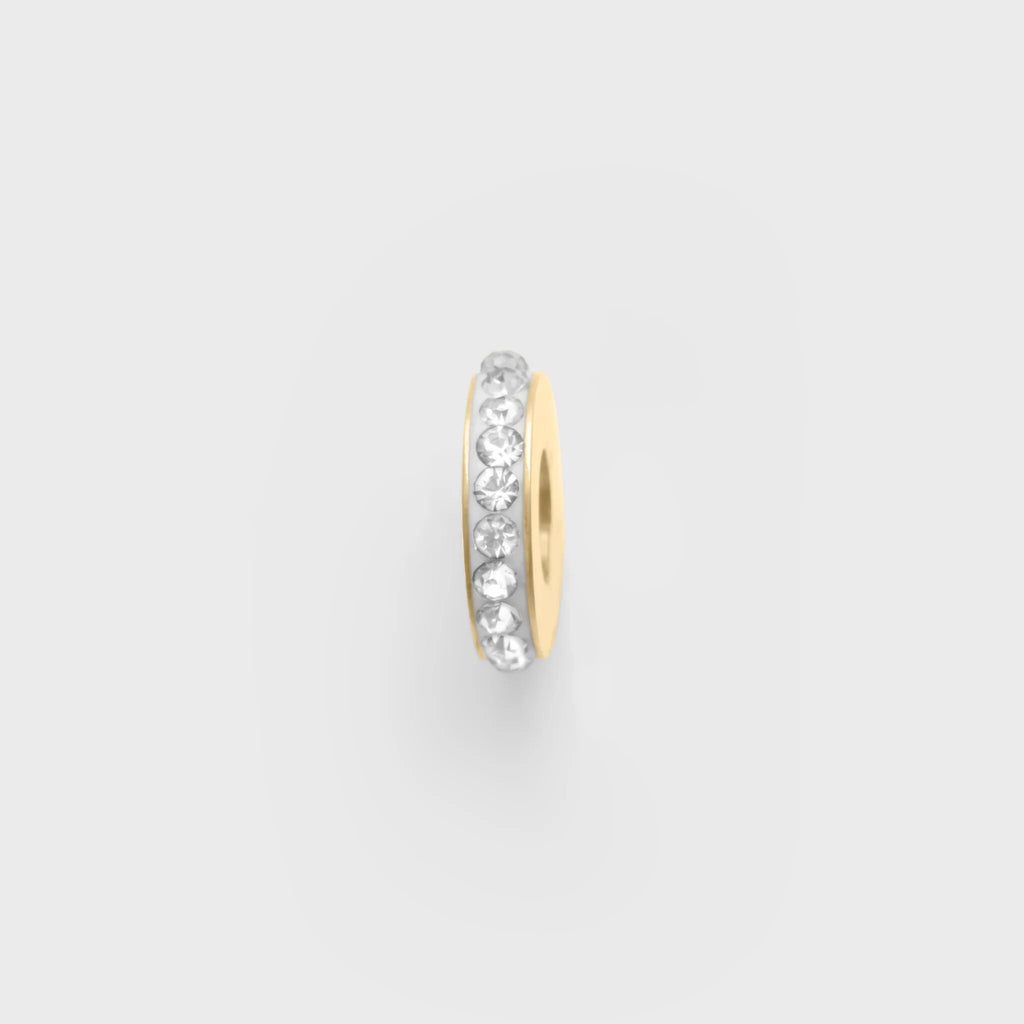 Gold spacer bead with embedded cz stones on a light gray background
