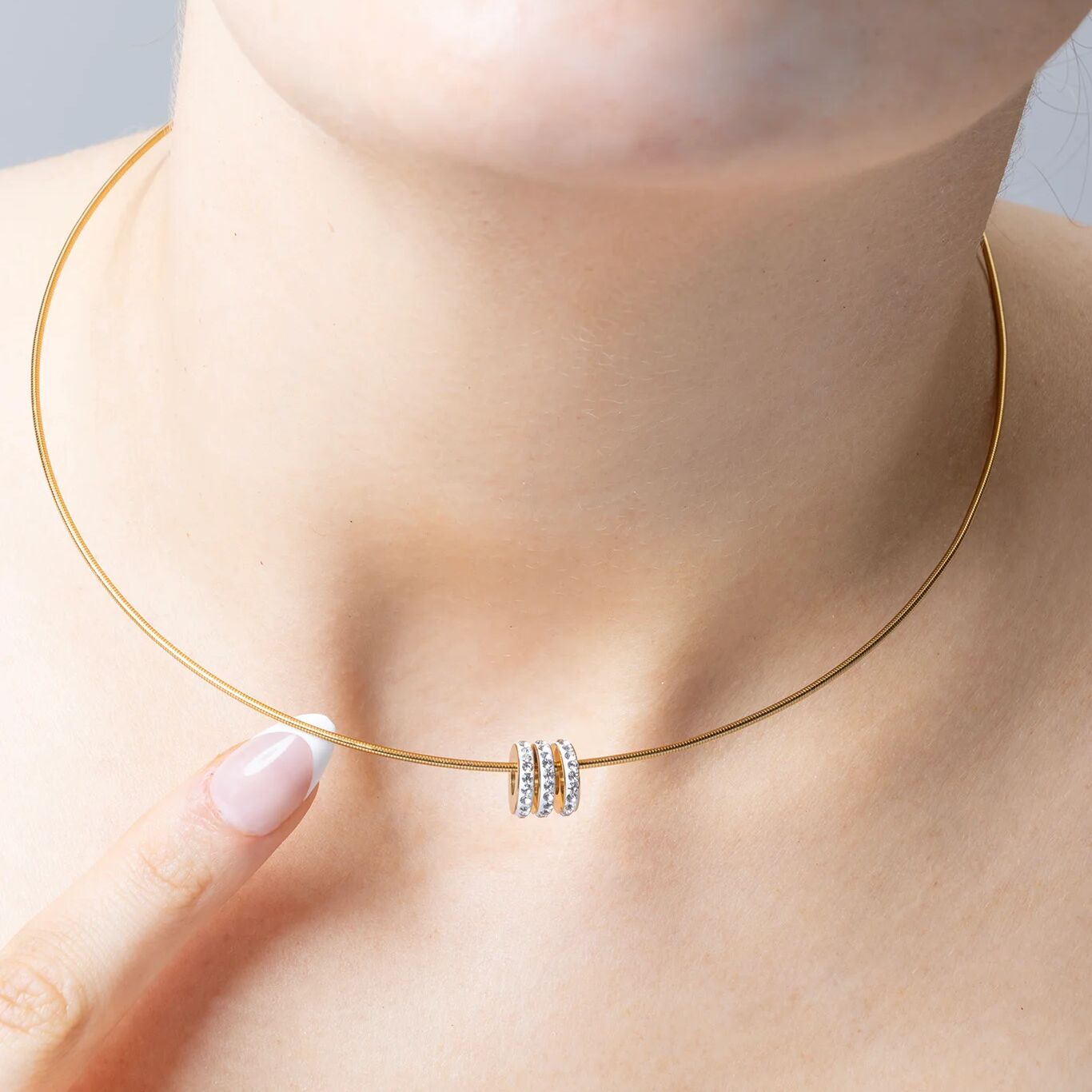 Gold necklace with a small spacer beads on a person's neck