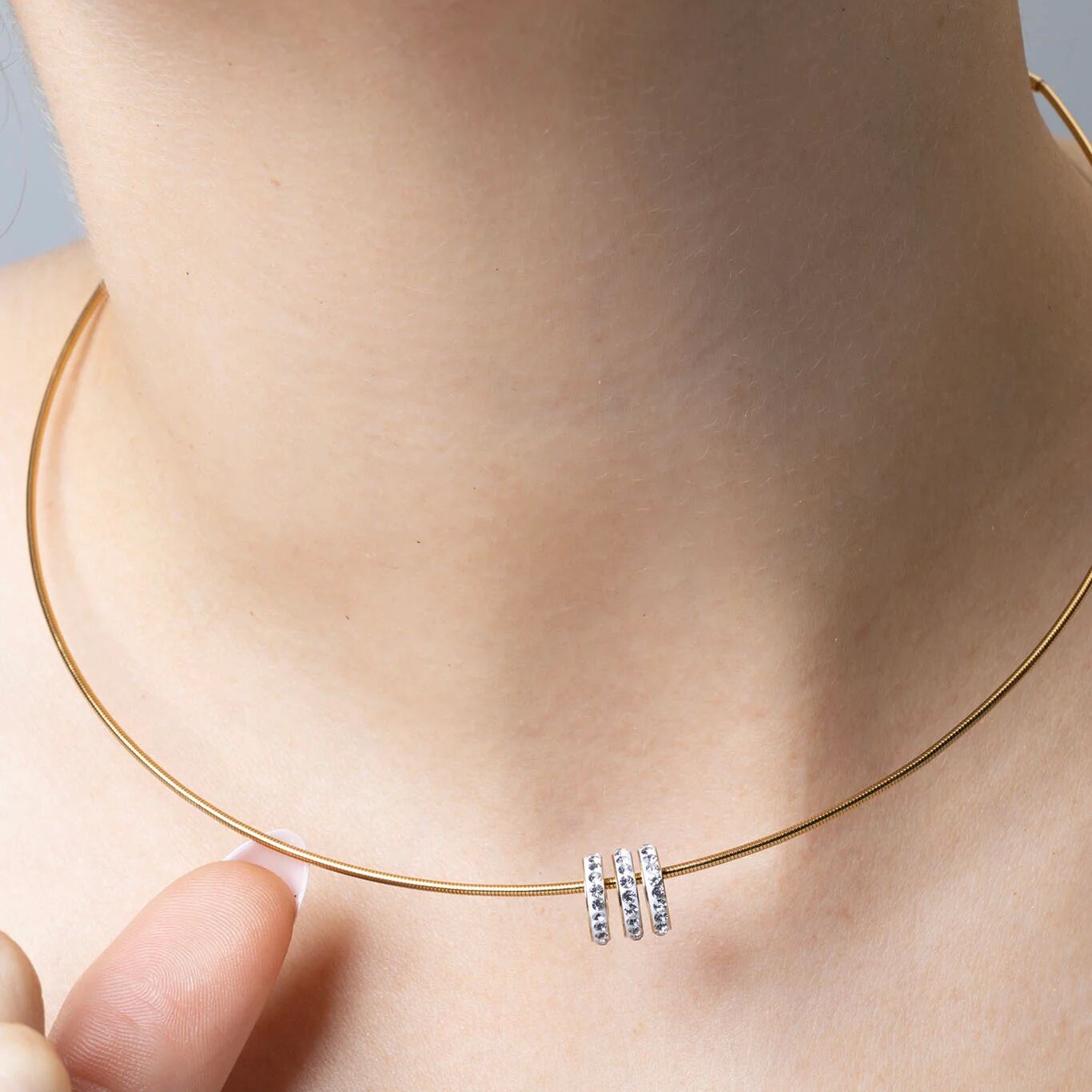 Gold necklace with spacer beads on a person's neck