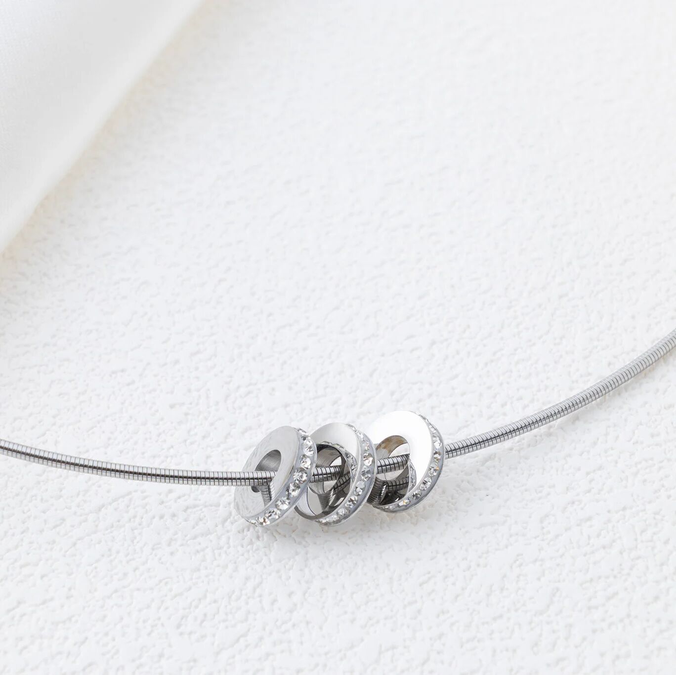 Silver necklace with spacer beads on a white background