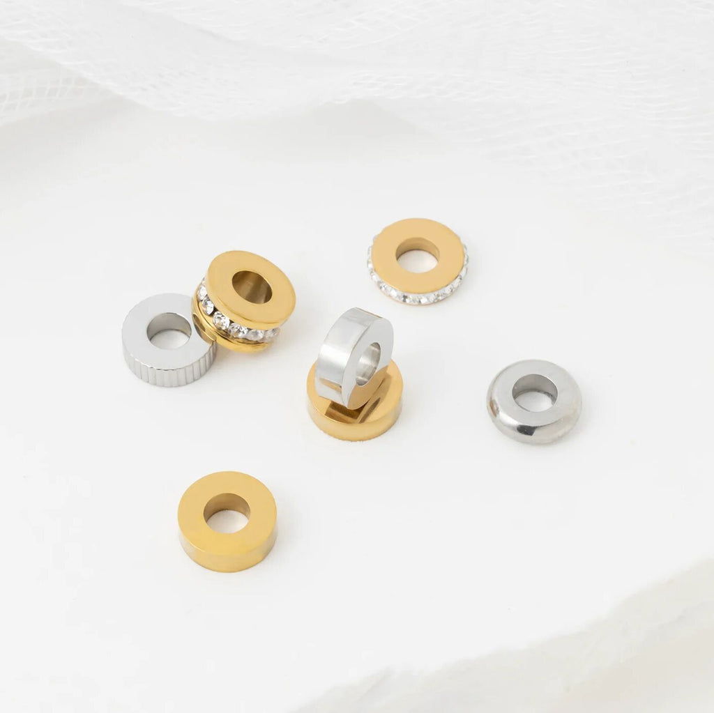 Set of spacer beads in gold and silver on a white background