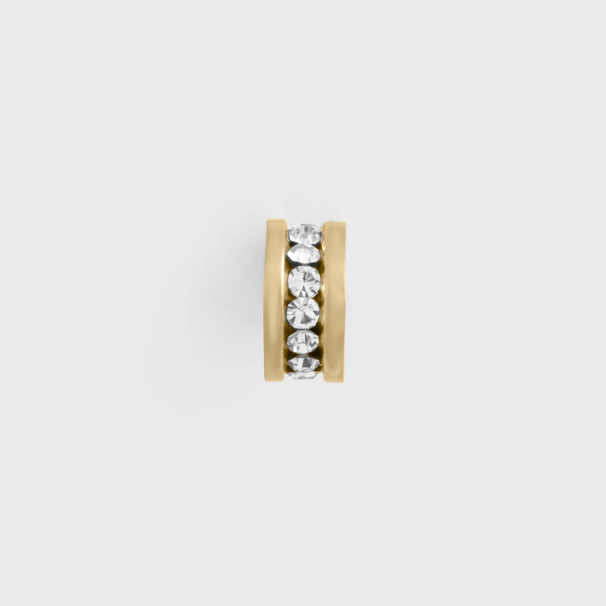 Gold spacer bead with embedded crystals on a light gray background