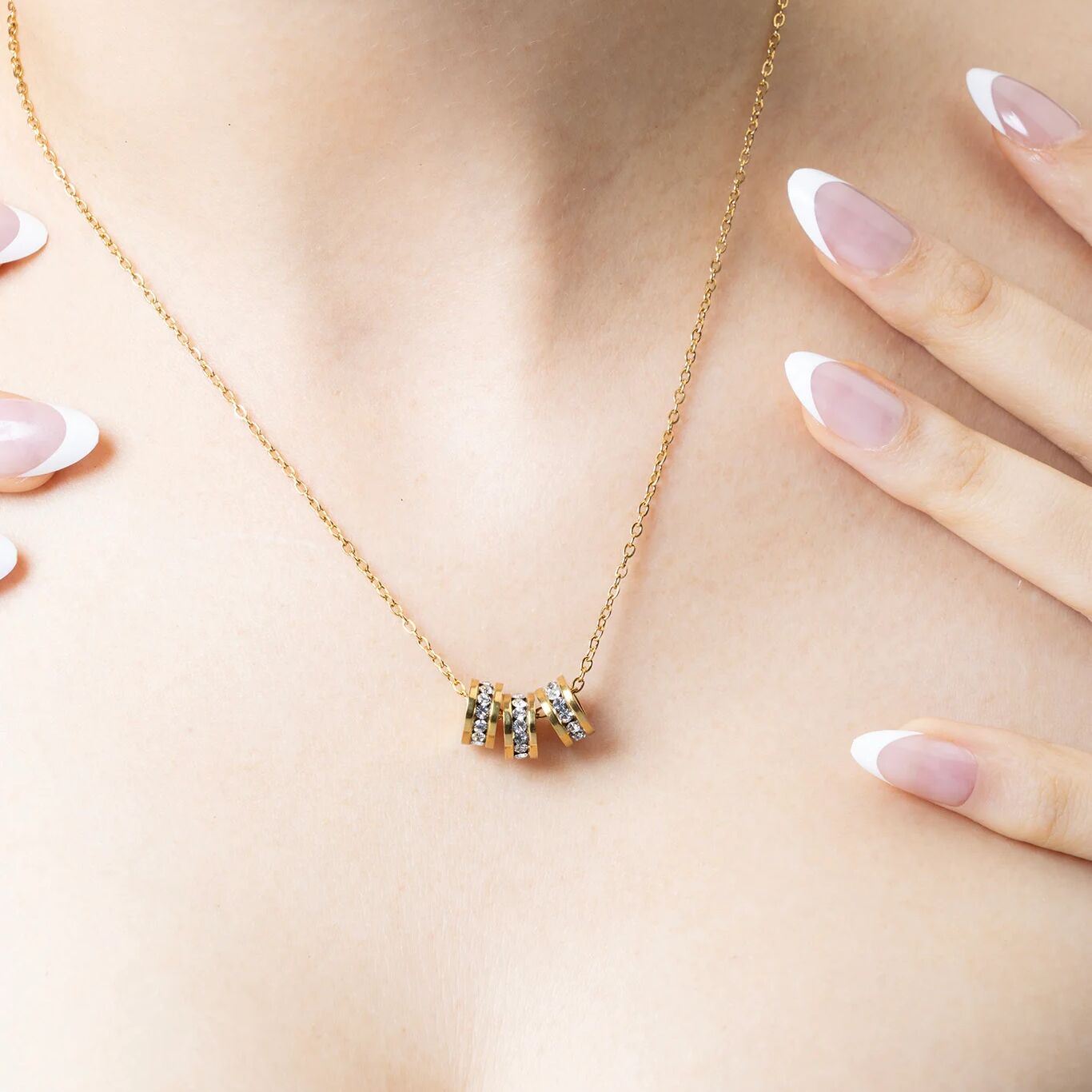 Gold necklace with a small spacer beads on a person's neck