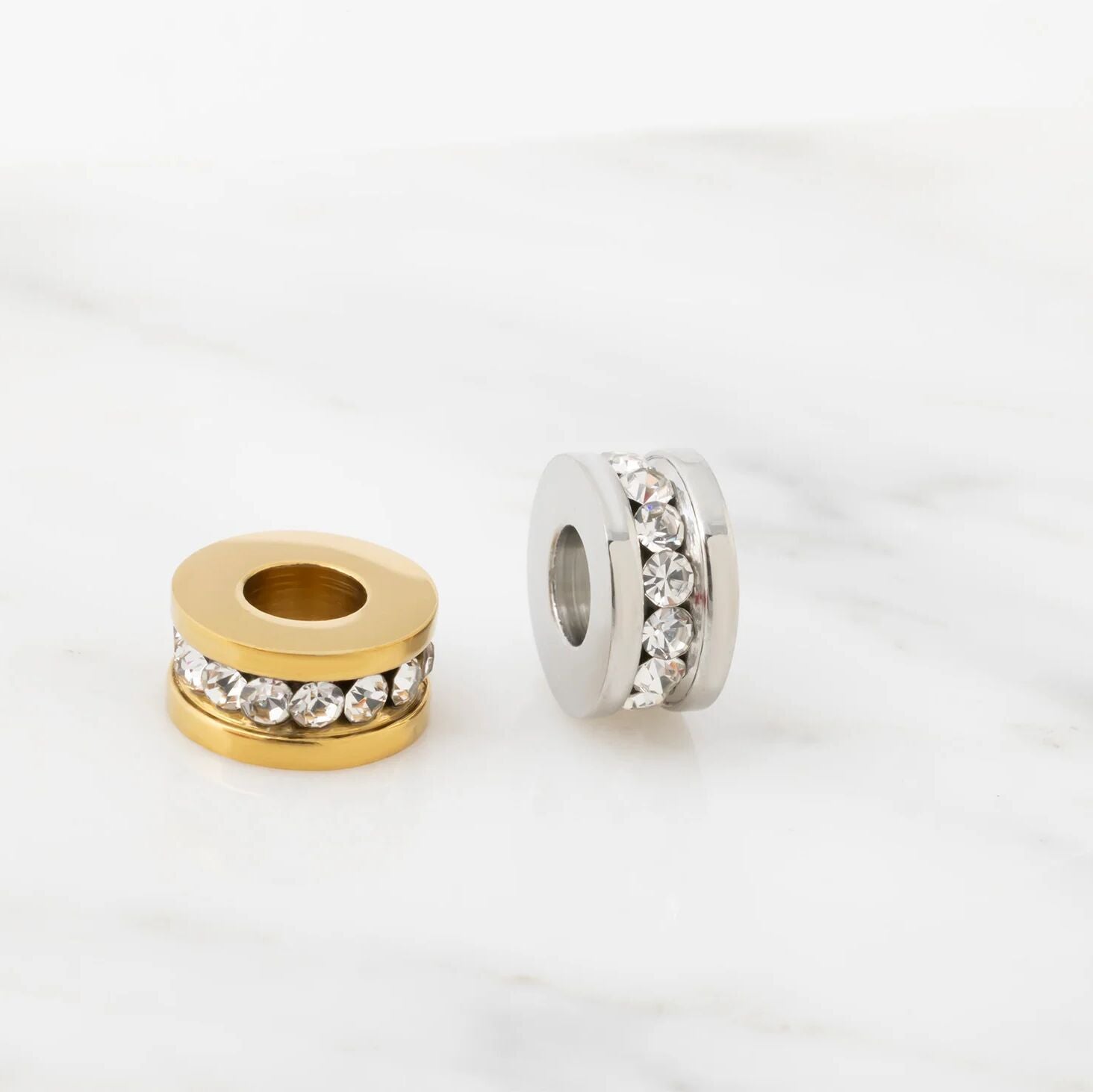 Two spacer beads with gemstone accents on a white background