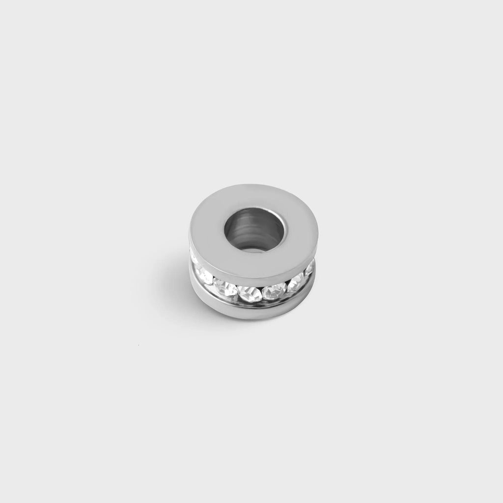Silver spacer beads with embedded stones on a light gray background