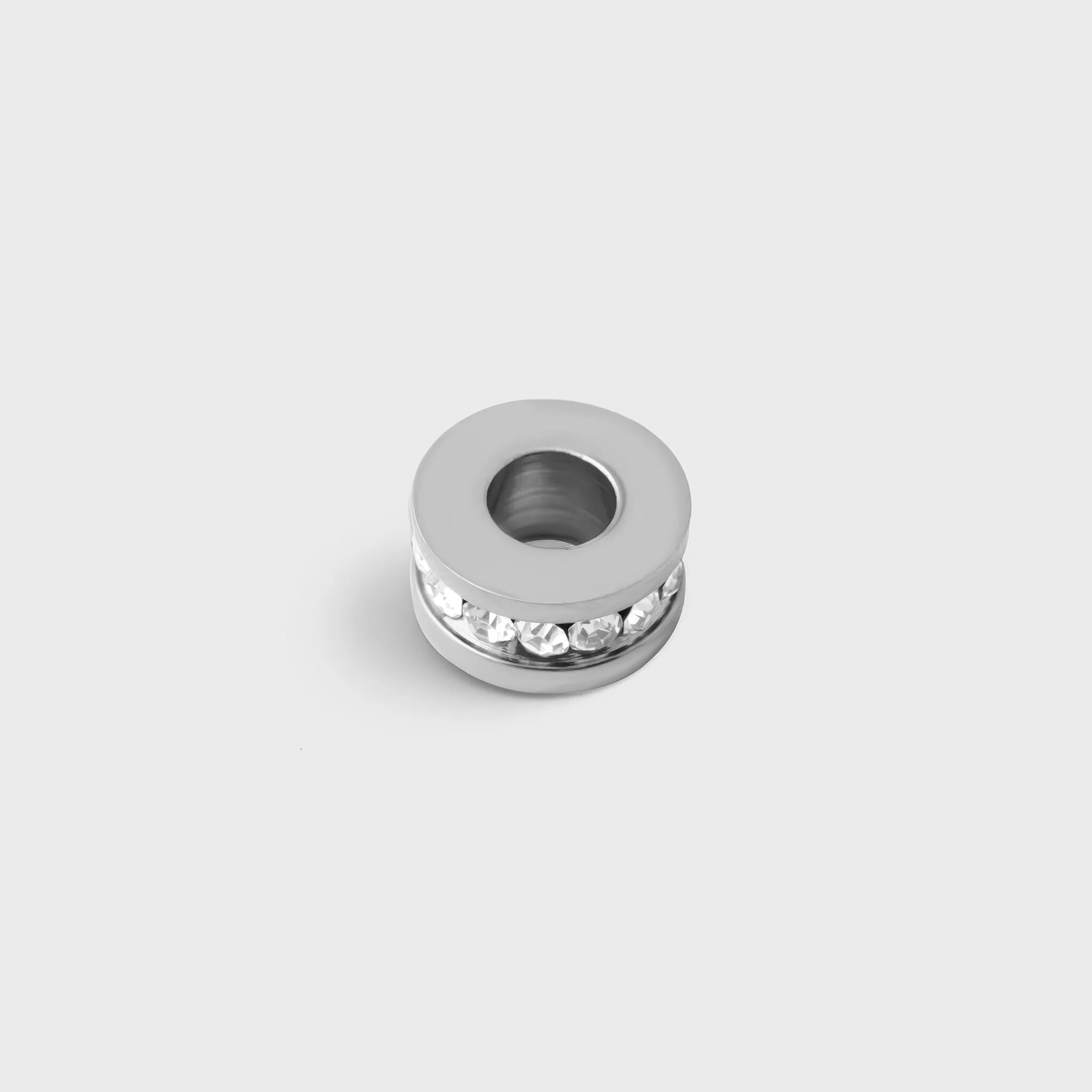 Silver spacer beads with embedded stones on a light gray background
