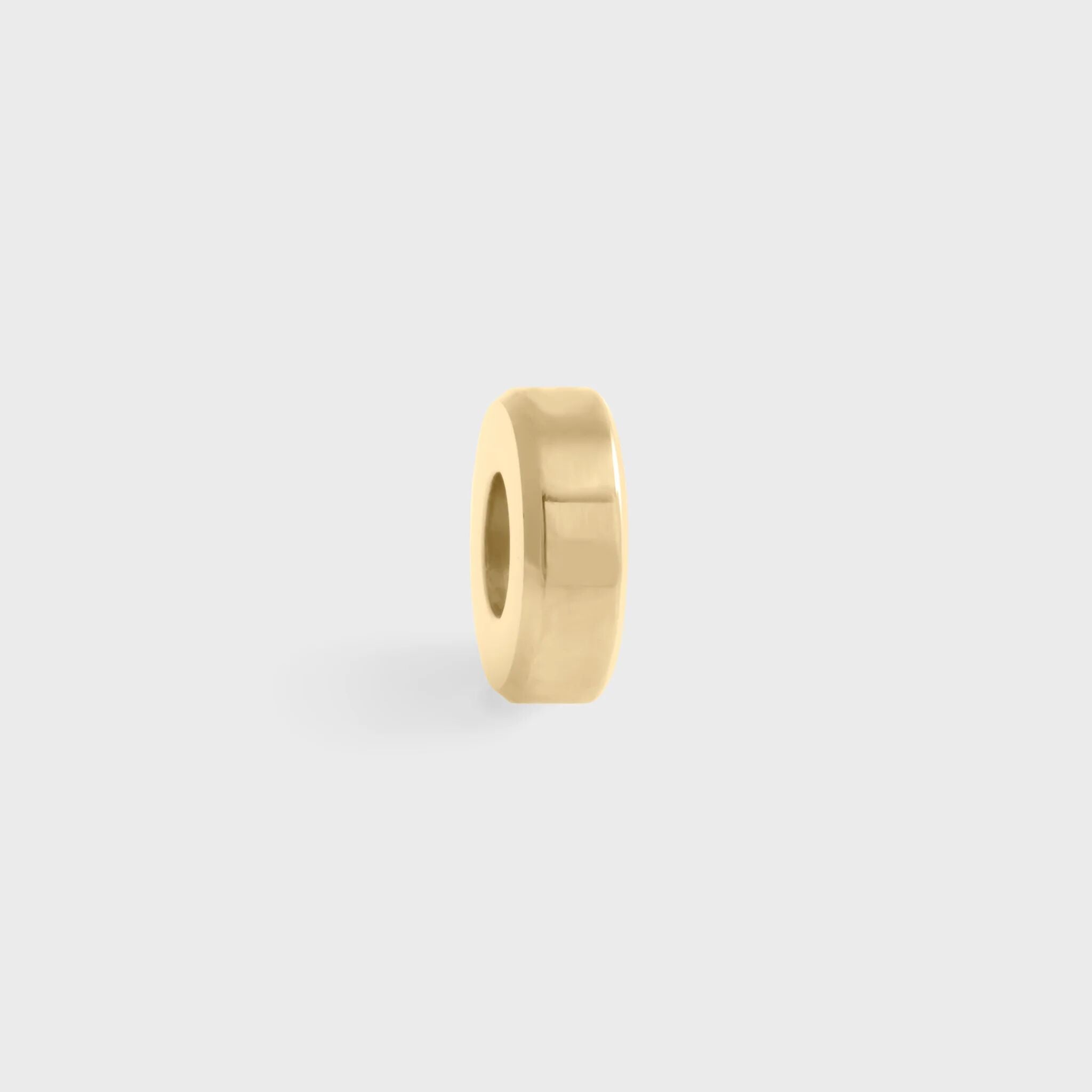Gold spacer bead on a light gray background