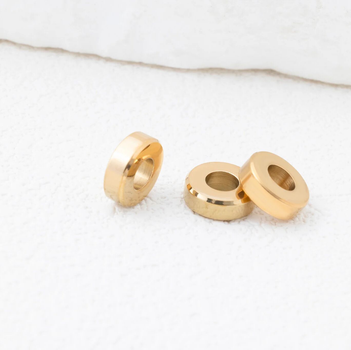 Gold spacer beads on a white background