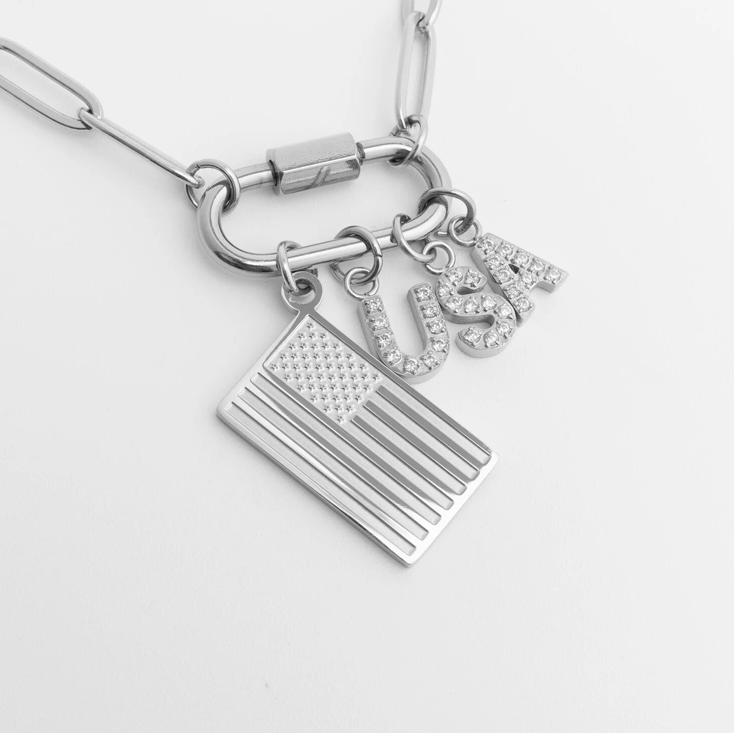 Silver bracelet with American flag and 'USA' charm on a light gray background