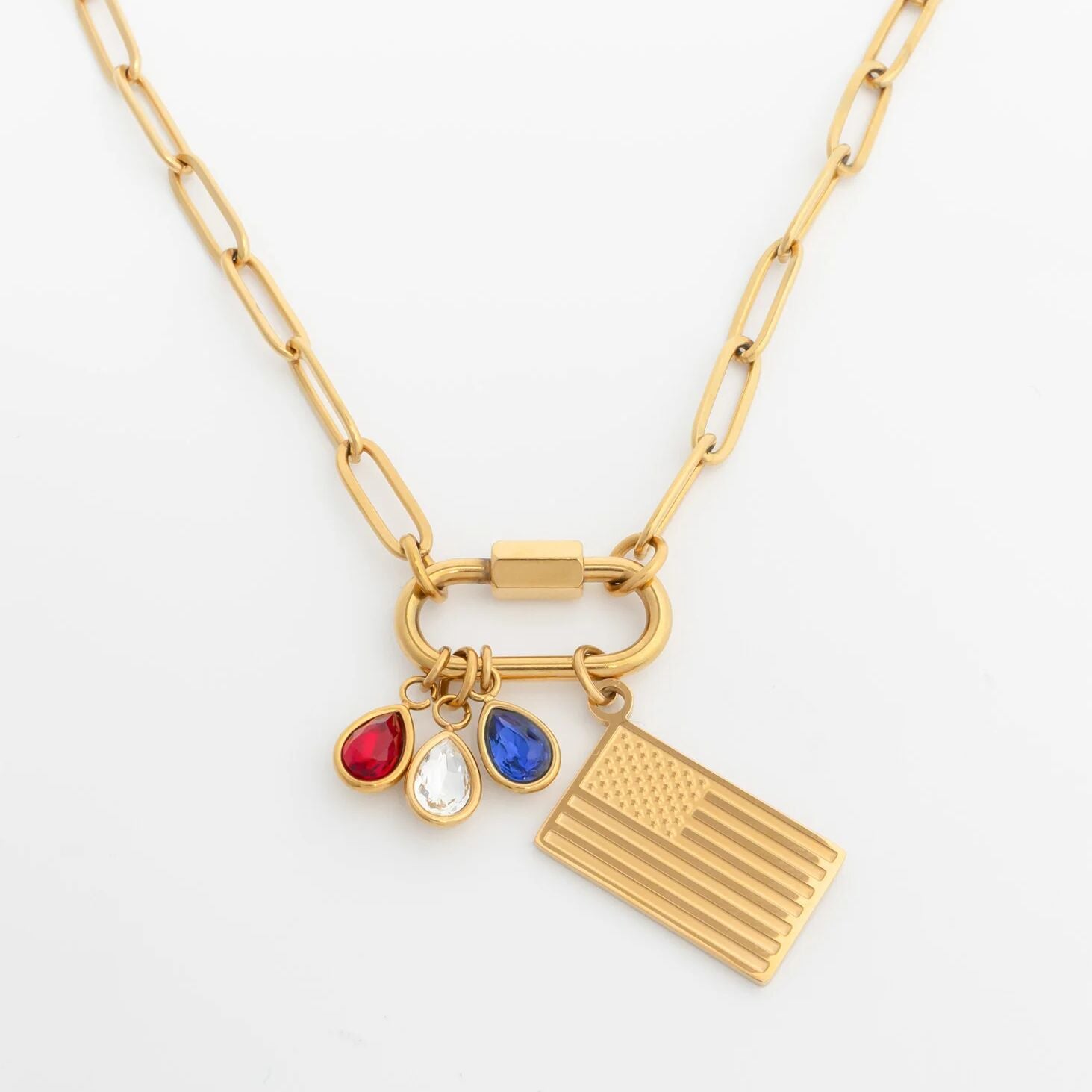 Gold necklace with three charms on a white background