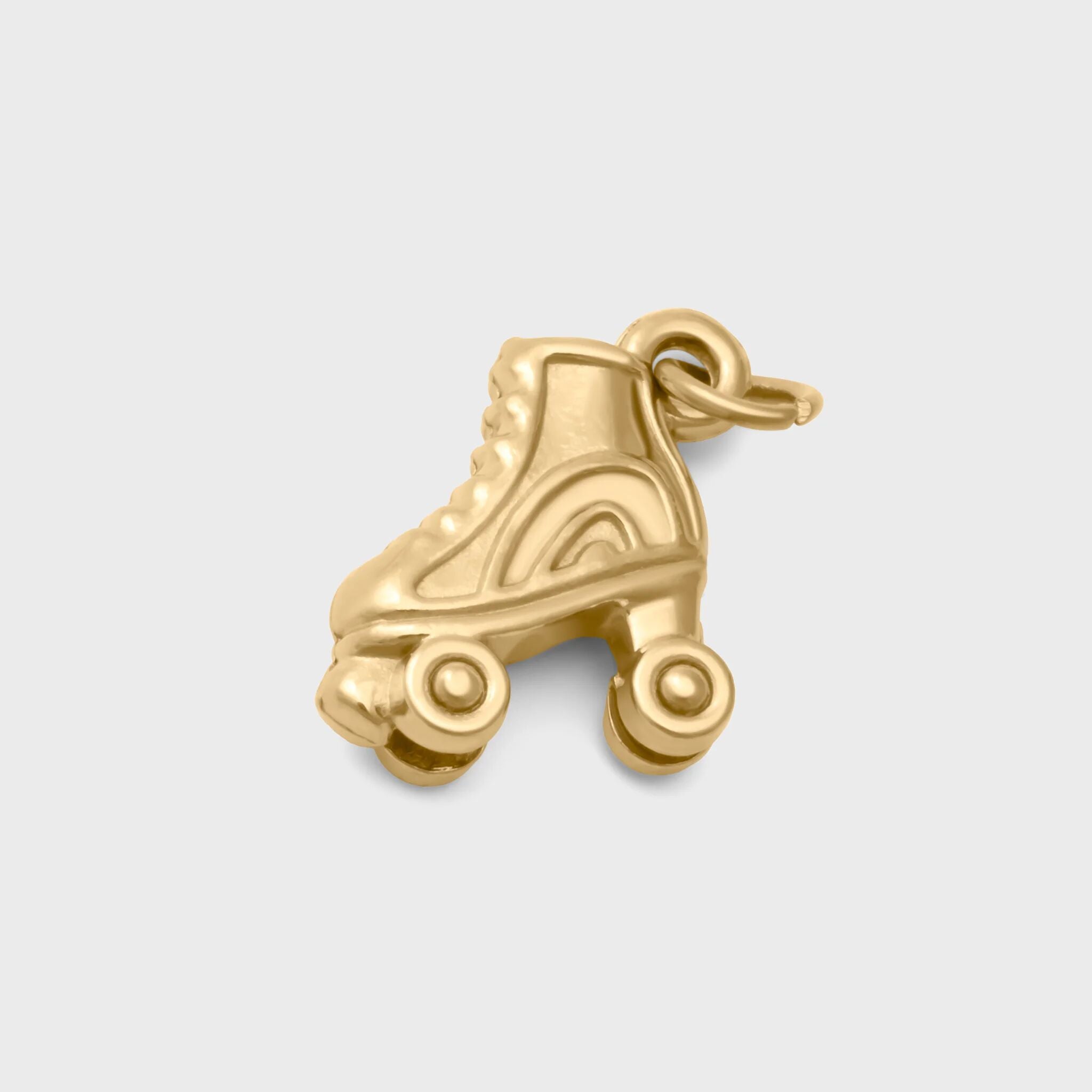Gold roller skate charm on a light gray background