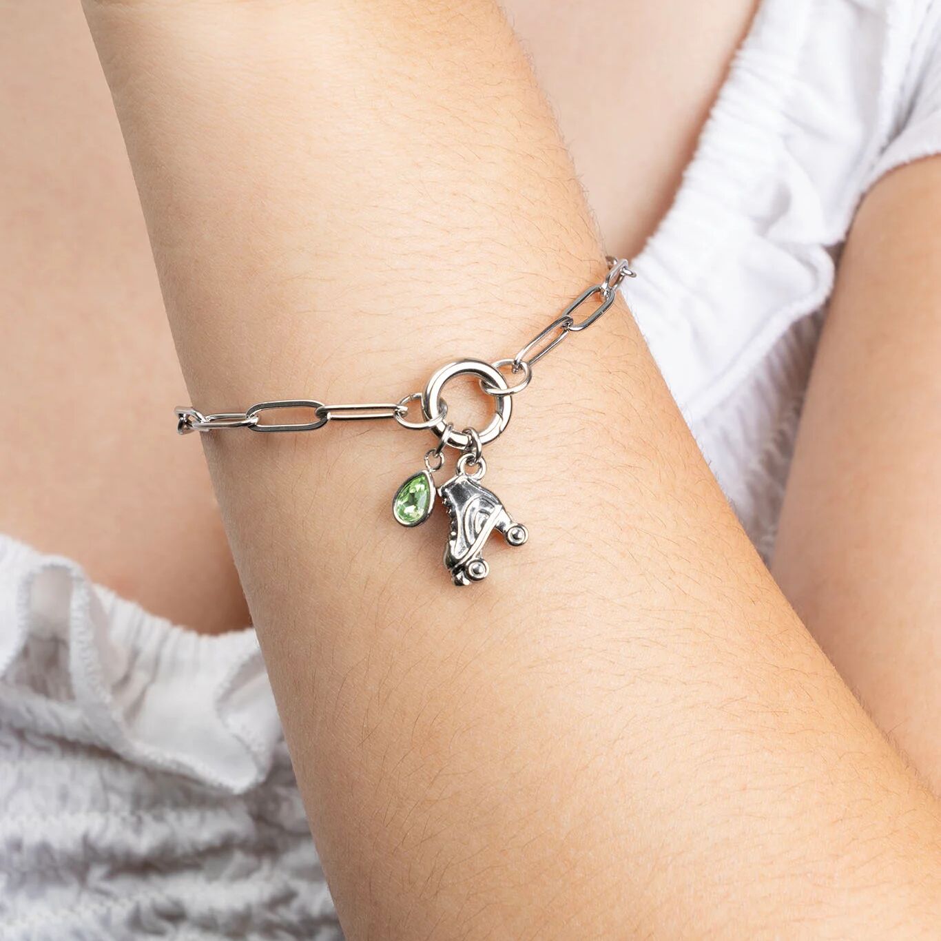 Silver bracelet with charms on a person's wrist