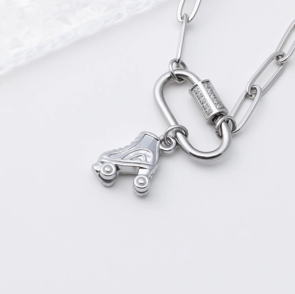 Silver necklace with a roller skate charm on a white background