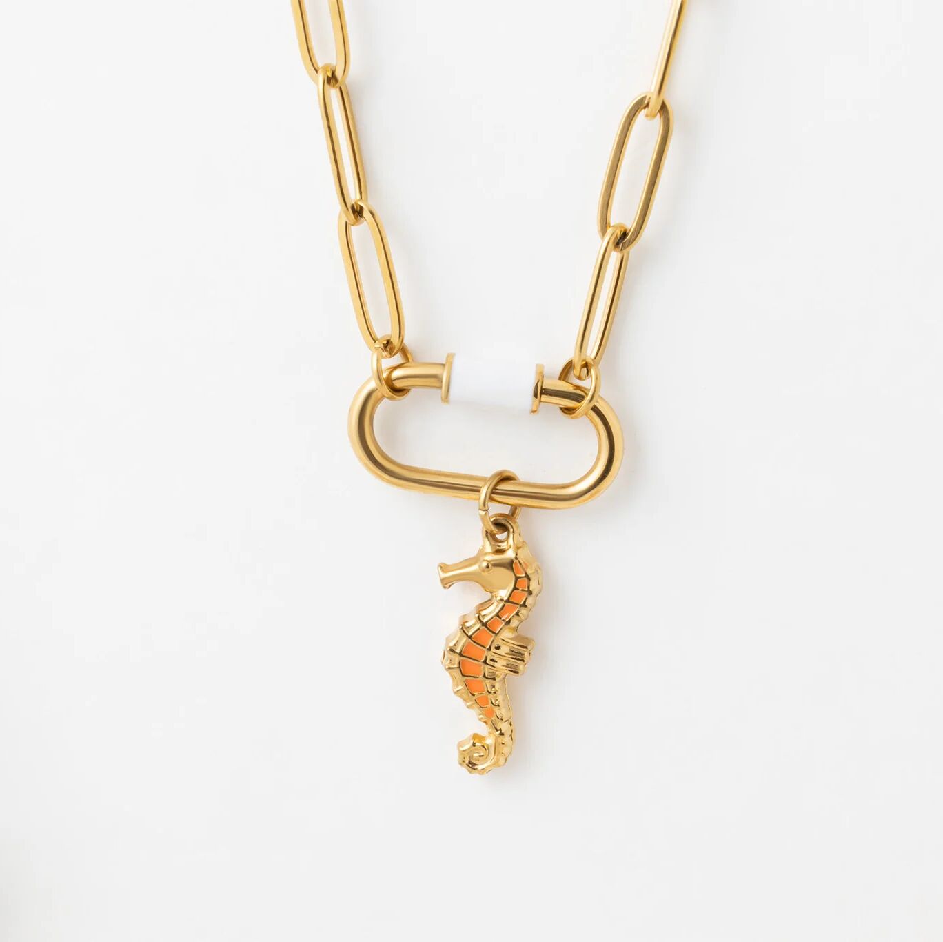 Gold chain necklace with a seahorse pendant on a white background
