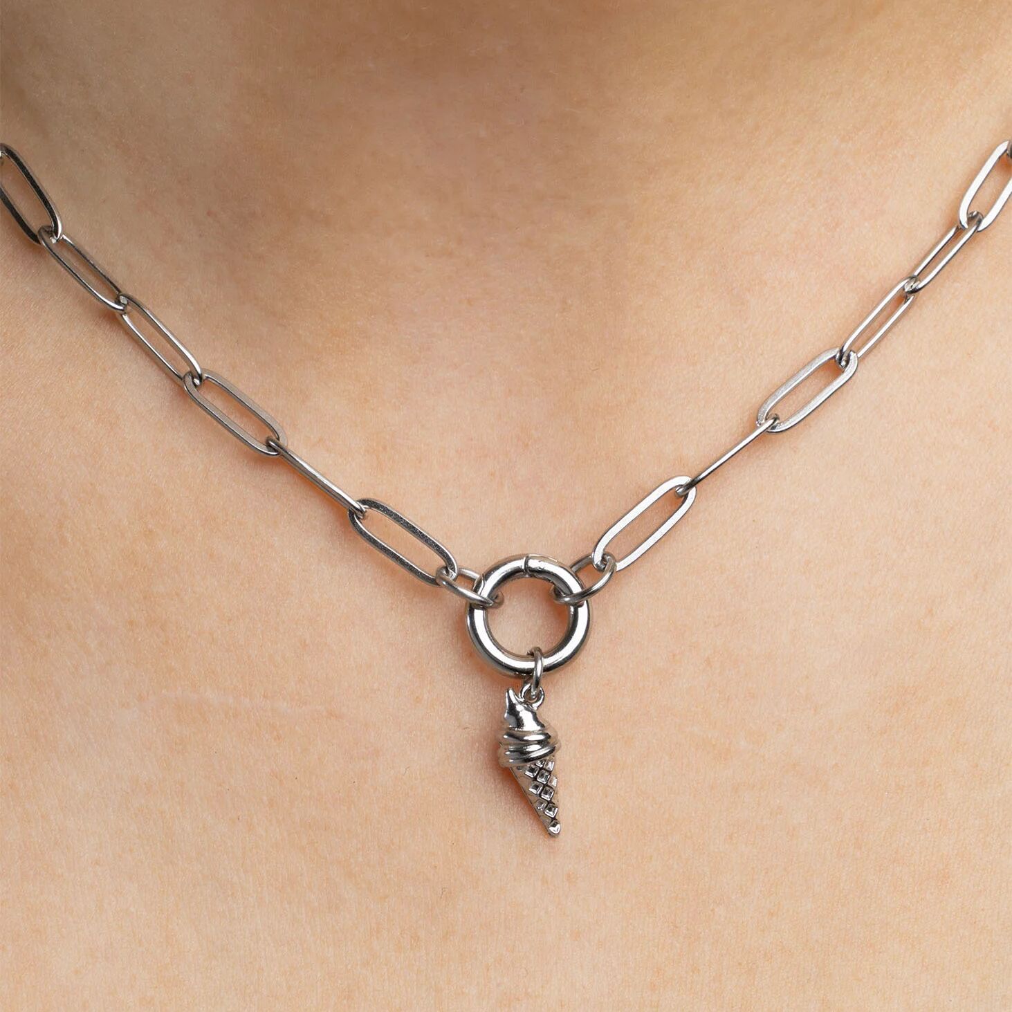 Silver chain necklace with an ice cream cone pendant on a person's neck