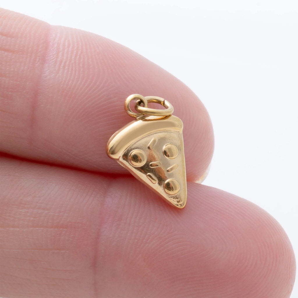 Gold pizza slice pendant held between fingers on a white background