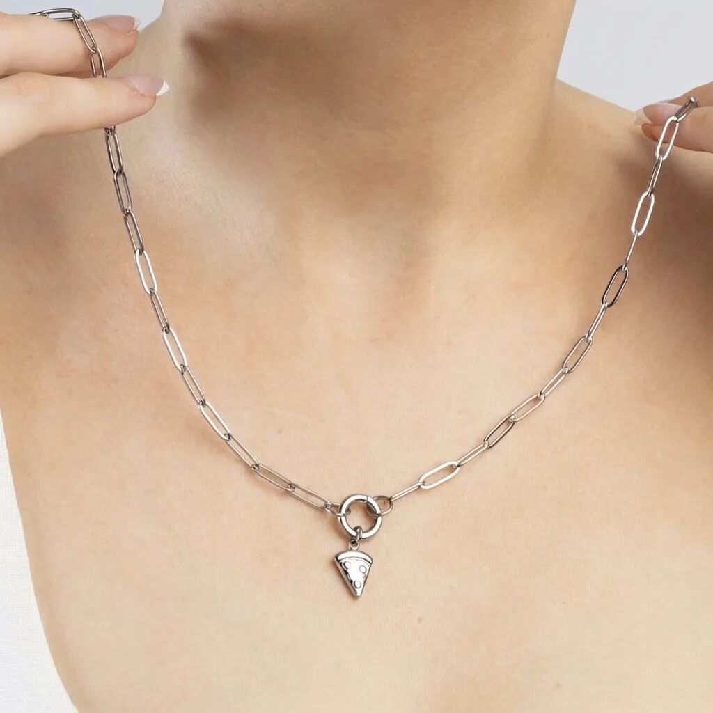 Silver necklace with a pendant on a person's neck against a neutral background
