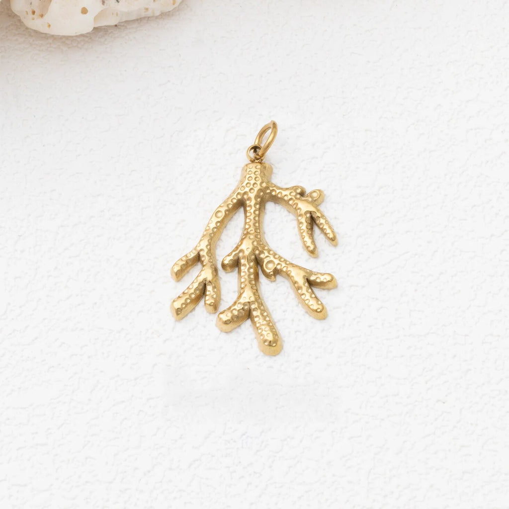 Gold coral pendant on a white background