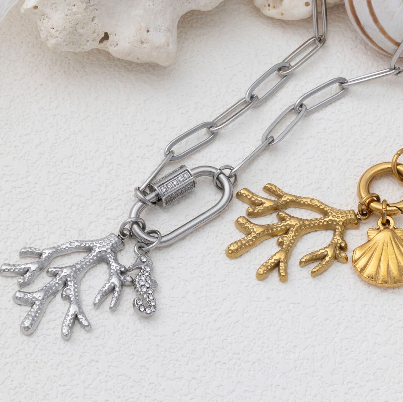 Jewelry with coral and shell charms on a textured surface