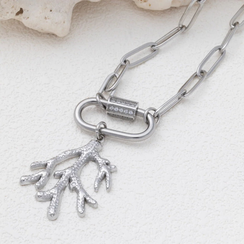Silver chain necklace with a coral pendant on a light background
