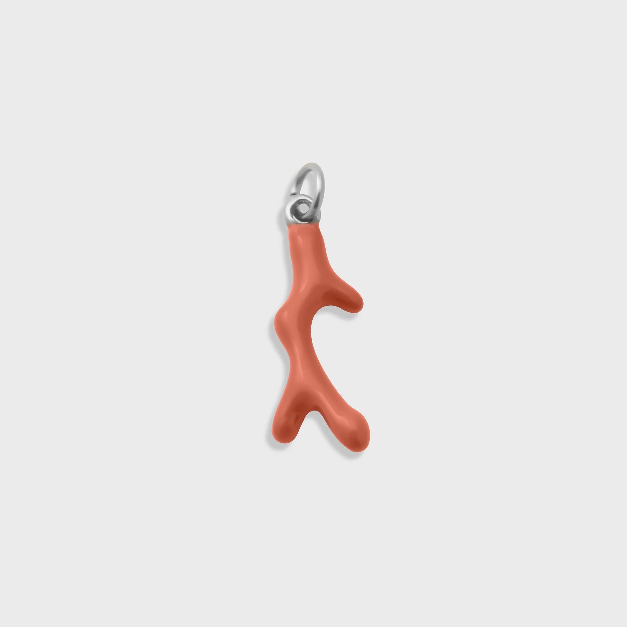 Coral-shaped pendant with a silver clasp on a light gray background