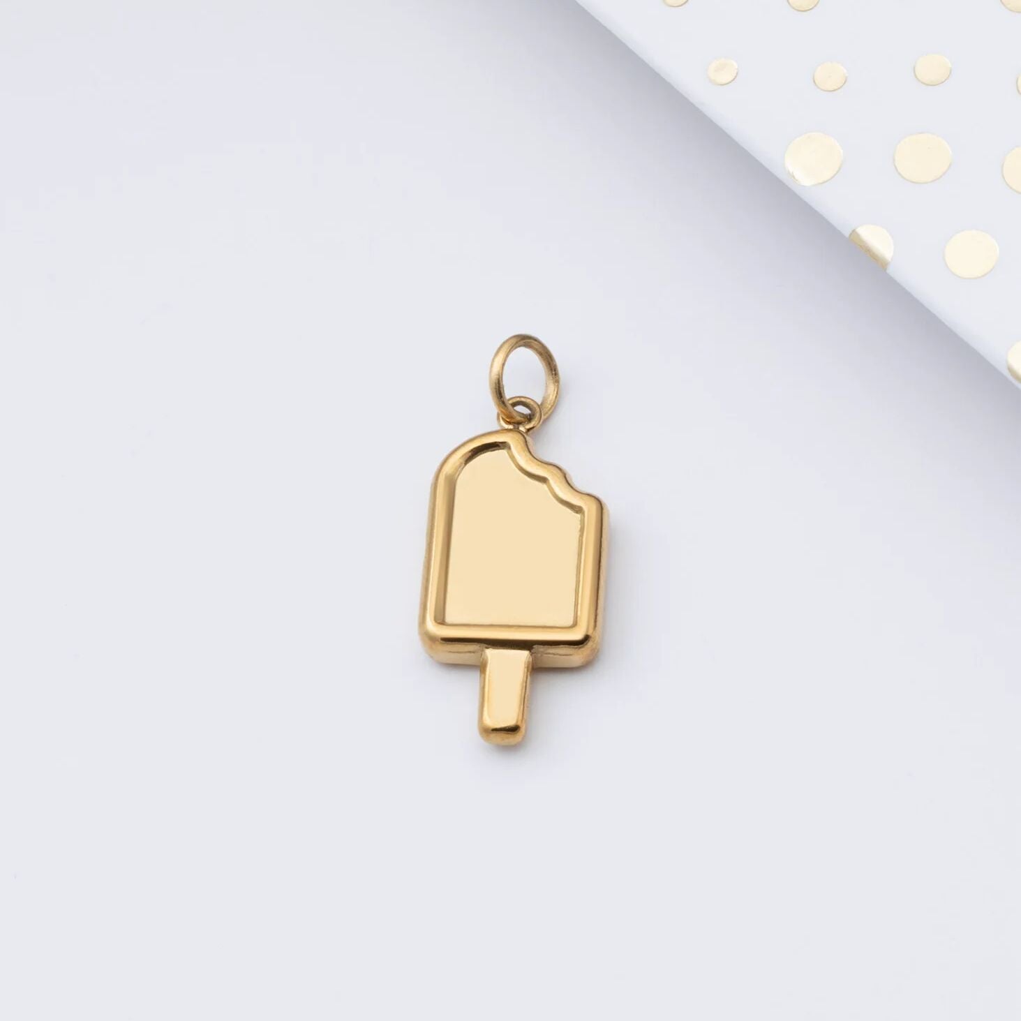Gold popsicle-shaped pendant on a light gray background