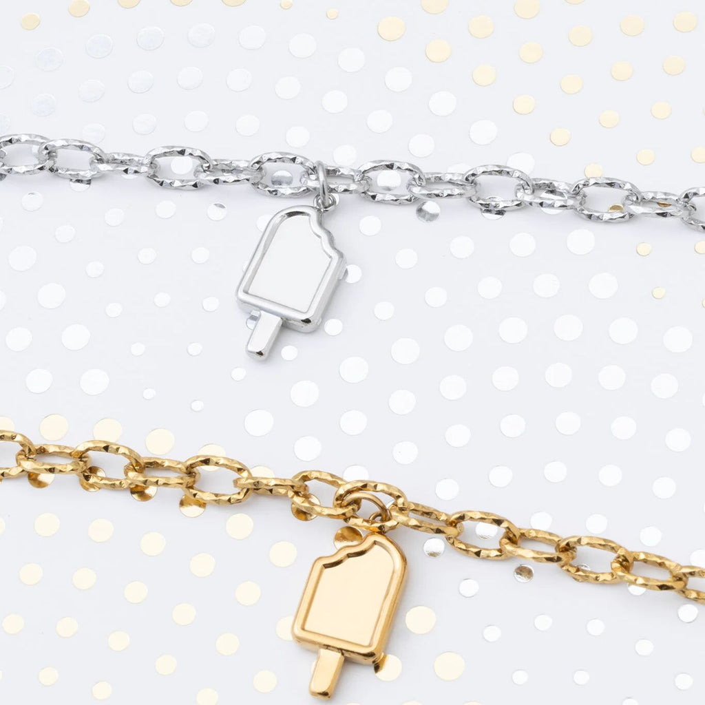 Two bracelets with popsicle charm pendants on a white background with gold polka dots.