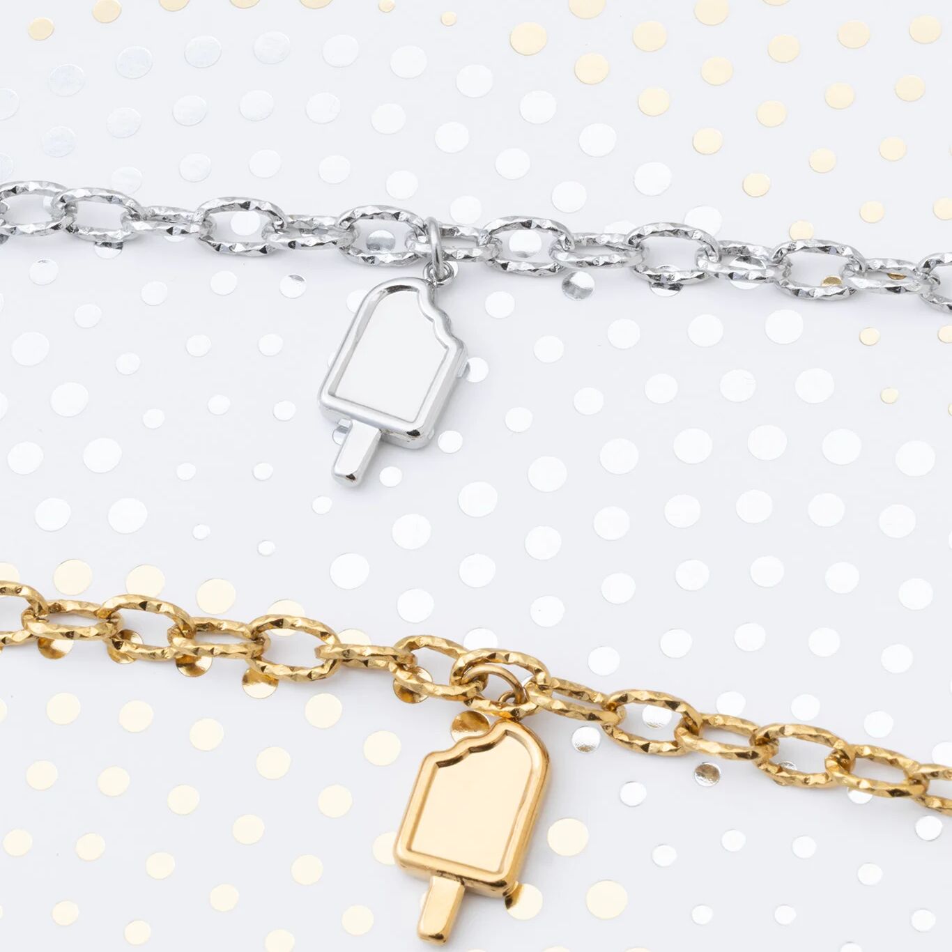 Two bracelets with popsicle charm pendants on a white background with gold polka dots.