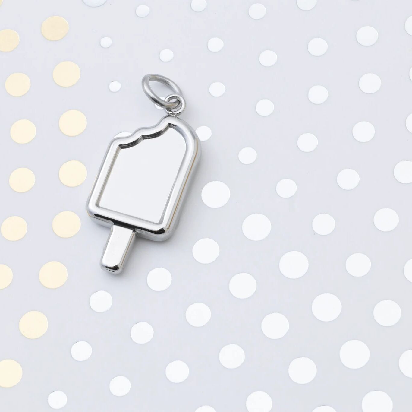 Silver popsicle pendant on a polka dot background