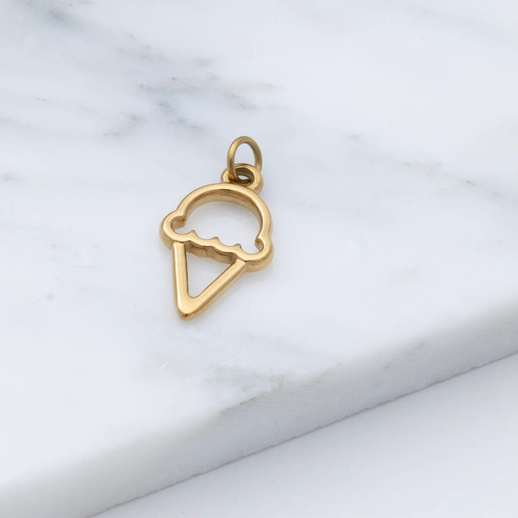 Gold ice cream cone pendant on a marble surface