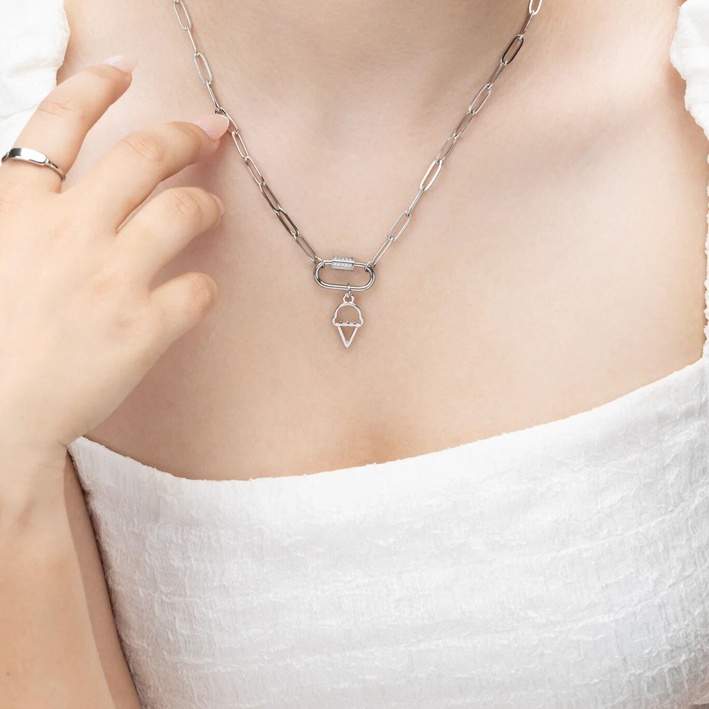Silver necklace with a ice cream pendant on a person wearing a white top.