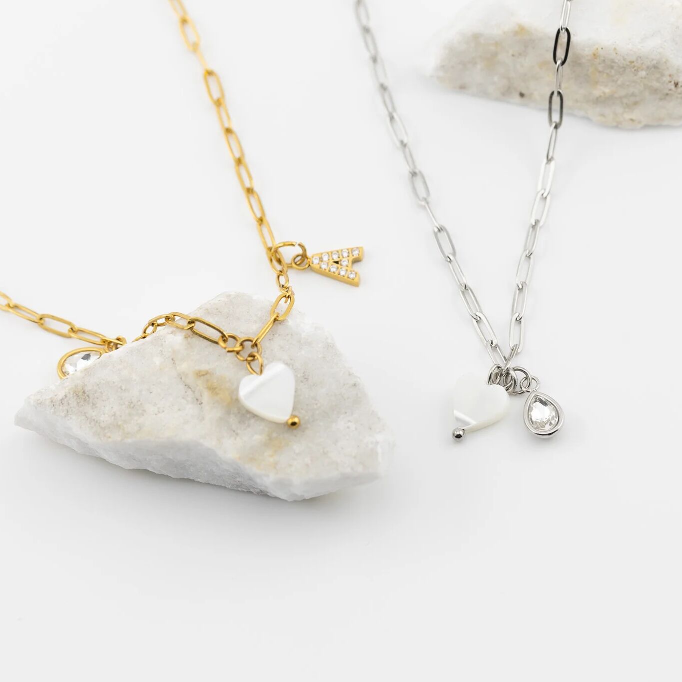 Two necklaces with heart and circular pendants on a white background