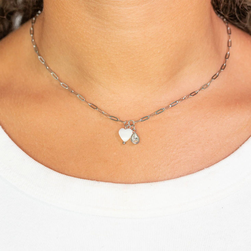 Necklace with heart-shaped charms worn by a person on a white background