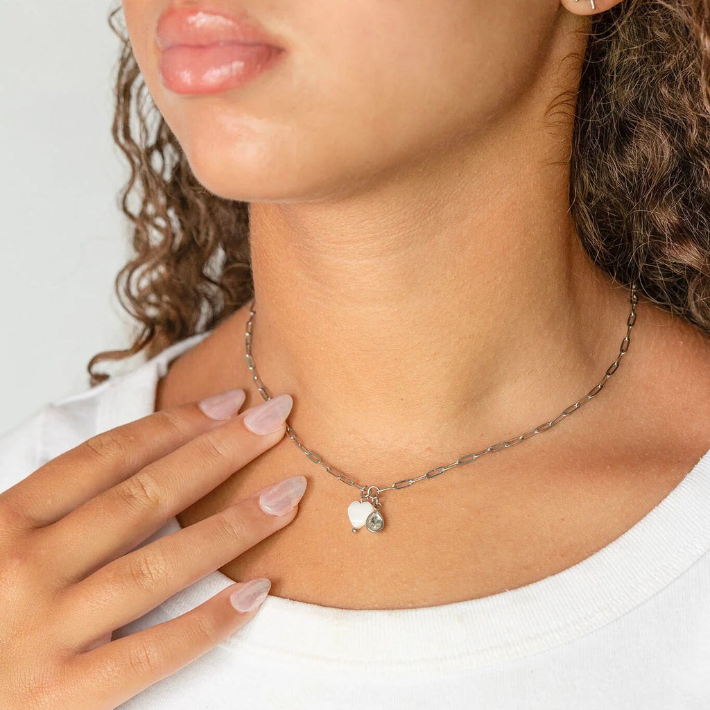 Necklace with a heart shell charm worn by a person