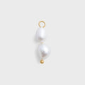 Pearl charm with gold hook on a light gray background