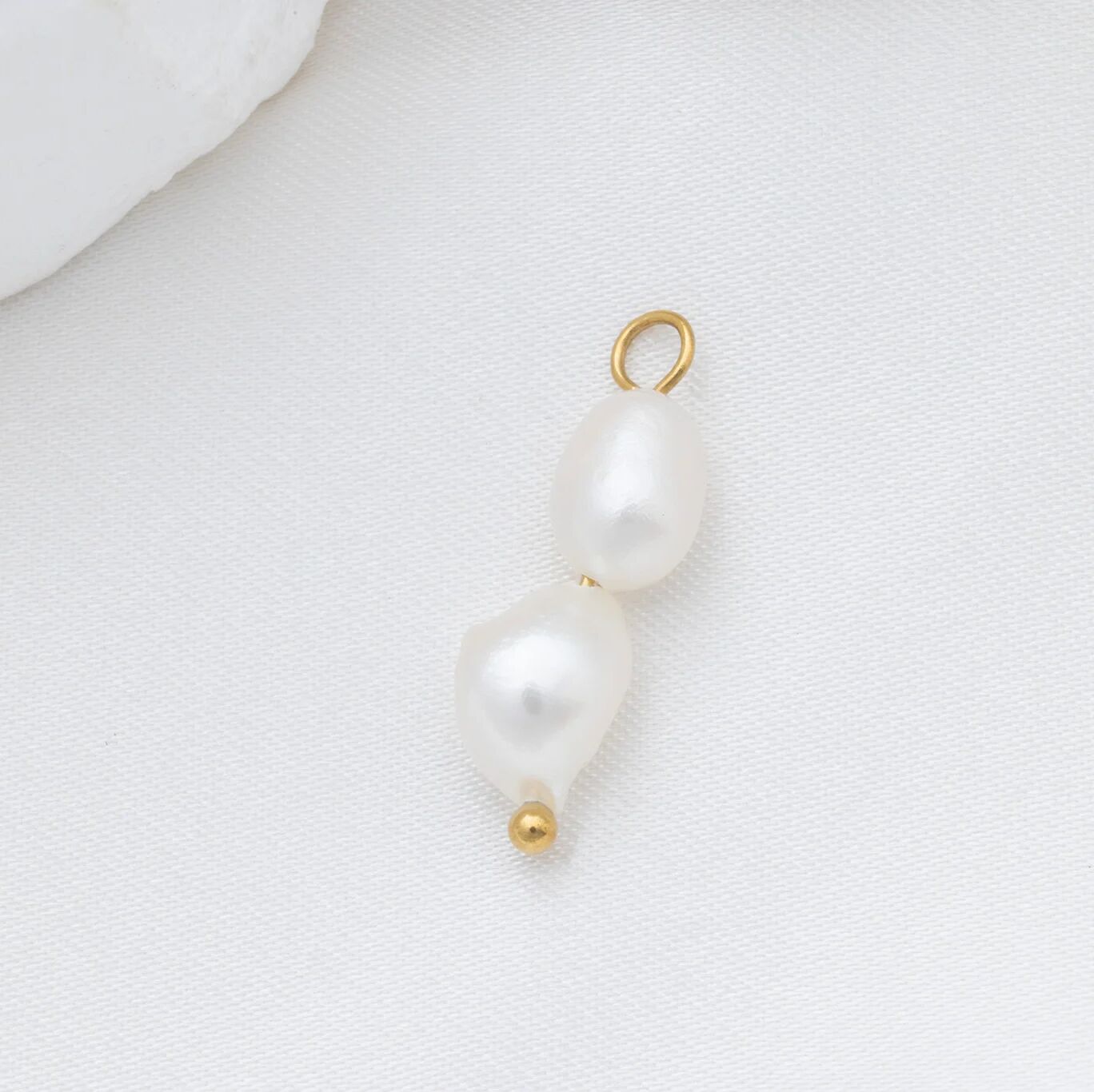 Pearl pendant with gold clasp on a white background