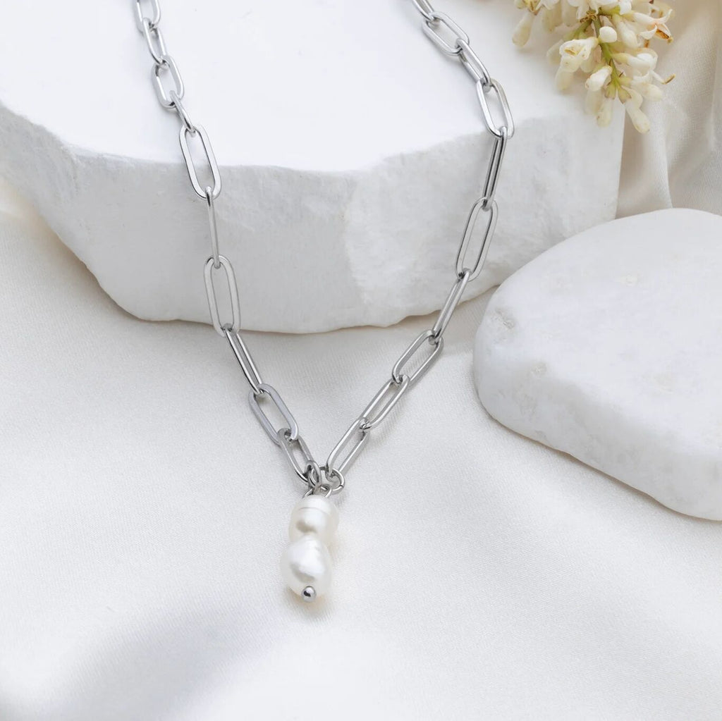 Silver chain necklace with a pearl pendant on a white background